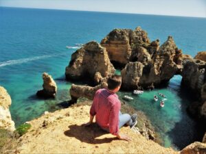 Сижу на скале Понте-де-пьедаде, Альгарве, поездка в Португалию