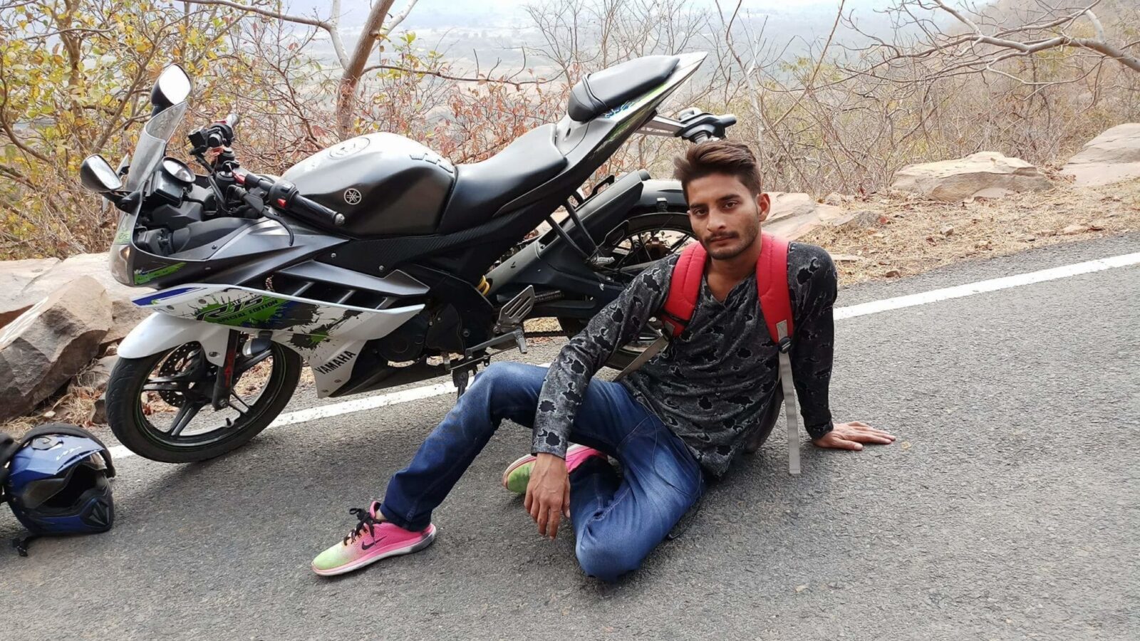 Biker next to a cruiser motorcycle wearing jeans