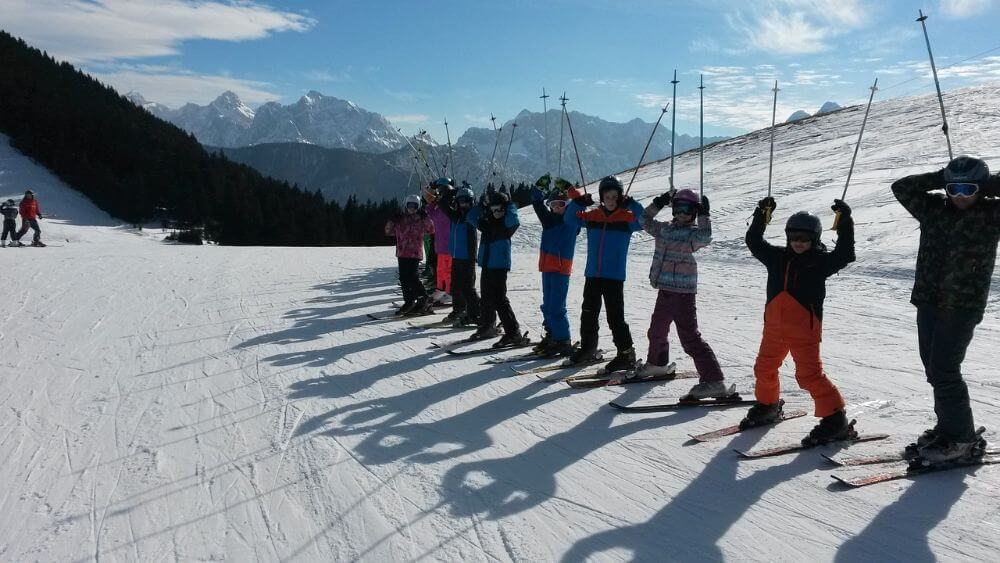Kids skiing on a winter mountain resort for family holidays
