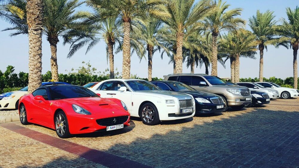 Luxury cars in Dubai near palm trees