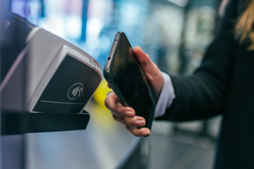 Człowiek w garniturze dokonuje płatności mobilne w celach biznesowych NFC technologia